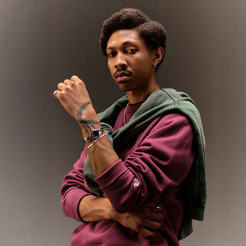 Man in red Champion sweater with a green sweater draped and tied over his shoulders