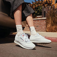 Close up of white sneakers on asphalt road