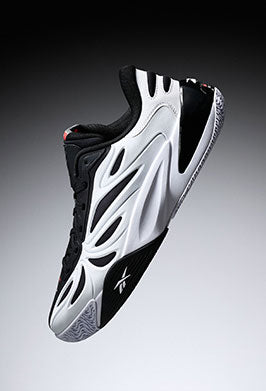 Black and white Reebok sneaker on gradient white and black background