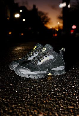 Pair of black DC winter shoes on a gravel ground at night