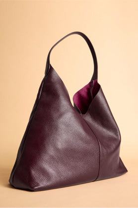 Dark red bag placed on plain yellow background