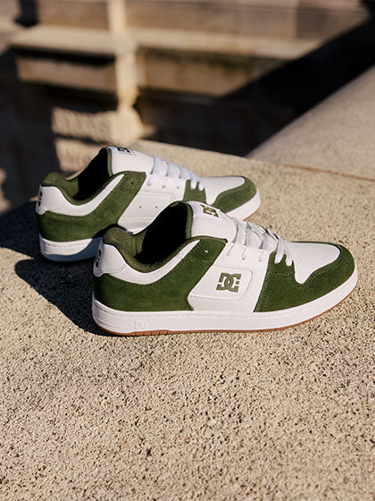 Green and white sneakers on a stone ground