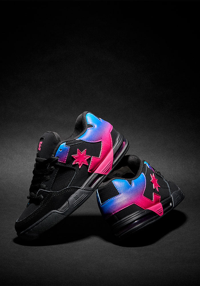 Pair of sneakers with pink and blue gradient DC print on black studio background