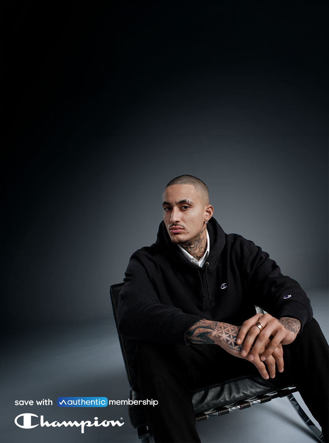 A person in black hoodie sitting against gray background with bottom left text reading "Save with Authentic Membership" and the Champion logo