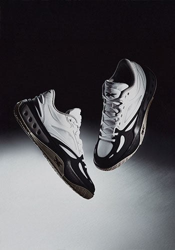 Pair of Reebok black and white sneakers floating in a black and white gradient space